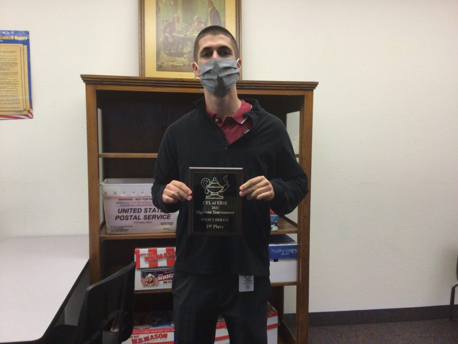 Mr. Fleming holding the plaque for first place for policy and debate in the diocese of Erie